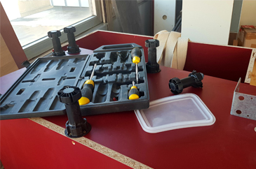 piros szétszerelt bútor, melyen szerszámok láthatóak